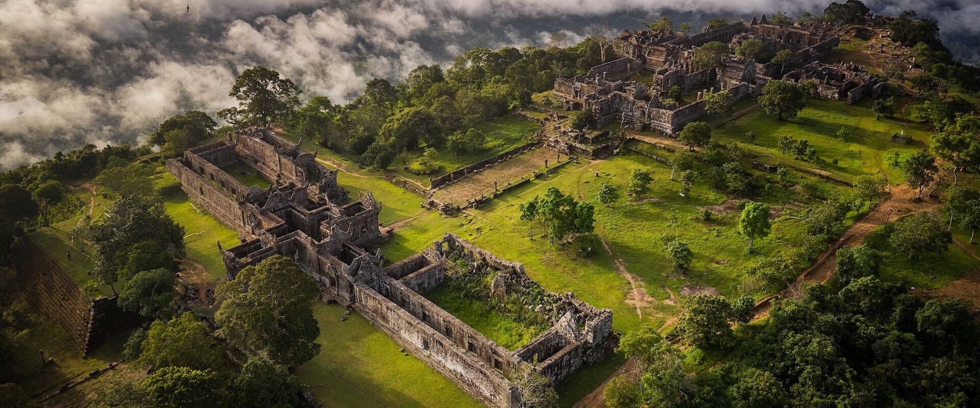 Preah Vihear’s ancient temple against lush hills on a Preah Vihear Travel banner by Legend Travel Group.